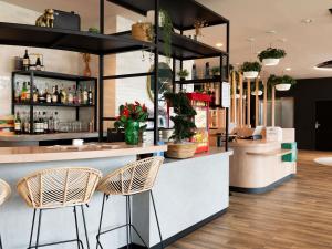 a bar in a restaurant with rattan chairs at Ibis Styles Rouen Centre Rive Gauche in Rouen