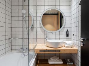 a bathroom with a sink and a mirror and a tub at Ibis Styles Rouen Centre Rive Gauche in Rouen +40 photos