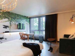 a hotel room with a bed and a table at Ibis Styles Rouen Centre Rive Gauche in Rouen