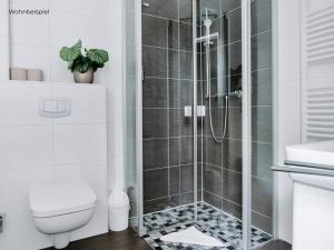 a shower with a glass door in a bathroom at Hotel Bloemfontein in Borkum +34 photos