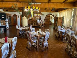 a dining room with tables and chairs and a chandelier at Stizhok Hotel & Restaurant in Berkhomet-pe-Siret