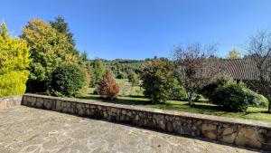 a stone retaining wall with trees in the background at Maison du cèdre in Bonnac-la-Côte +11 photos