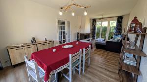 a living room with a red table and chairs at Maison du cèdre in Bonnac-la-Côte