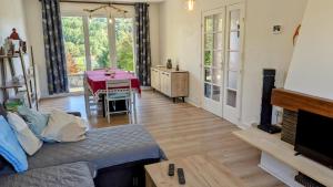 a living room with a couch and a table at Maison du cèdre in Bonnac-la-Côte