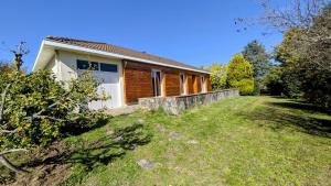 a wooden house with a yard in front of it at Maison du cèdre in Bonnac-la-Côte