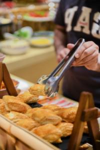 a person using a pair of tongs to eat food at Carat Hotel Yerevan in Yerevan