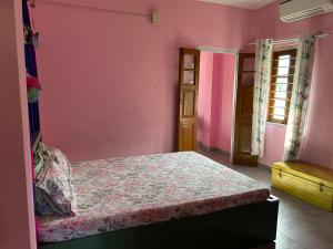 a bedroom with a bed in a pink wall at Luna's Solace-The Rustic Stay-Ease in Guwahati