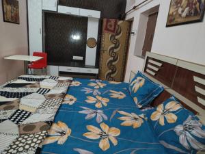 a bedroom with a blue bed with flowers on it at Mi HOMESTAY in Bikaner