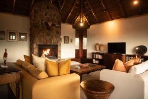 a living room with two couches and a fireplace at Tshwene Lodge in Vaalwater