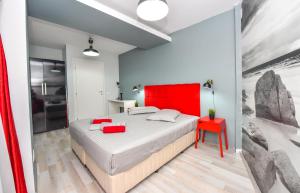 a bedroom with a large bed with a red headboard at Harmony Suites in Bucharest