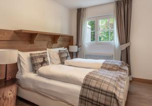 a bedroom with two beds and a window at Adler ApartHotel in Moena