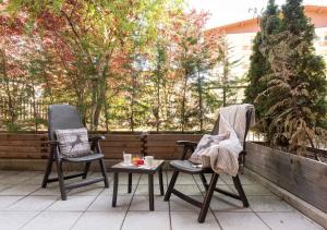 two chairs and a table on a patio at Adler ApartHotel in Moena