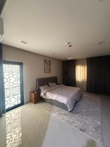 a bedroom with a large bed and a window at ليالينا in Dammam