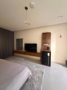 a bedroom with a bed and a flat screen tv at ليالينا in Dammam