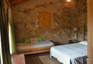 a bedroom with two beds in a stone wall at Casa rural Más La Torreta con vistas al Pla de Vistabella cerca del Peñagolosa Pet Friendly niños gratis in Vistabella del Maestrazgo