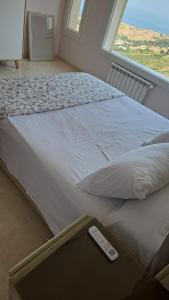 a bed with a remote control sitting on top of it at Exclusive luxury villa private pool and garden mnar in Tangier