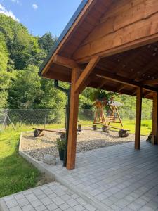 ein Holzpavillon mit Spielplatz in einem Park in der Unterkunft MaGórka in Krempna