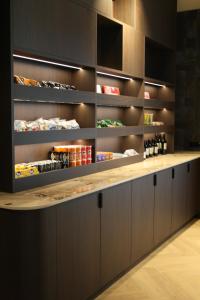 a kitchen with a counter with lots of shelves at Spaarnwoude Park Hotel in Velsen-Zuid