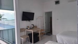 a bedroom with a desk with a television and a bed at DD Bangrak Hotel in Koh Samui