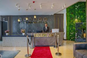 a man standing at a reception desk in a lobby at Vora Addis Hotel in Addis Ababa