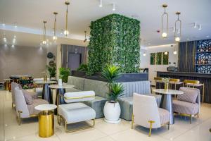 a restaurant with tables and chairs and a green wall at Vora Addis Hotel in Addis Ababa