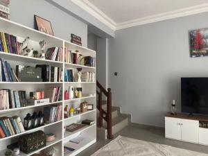 a white book shelf filled with books in a living room at Amazing home stays 3 in Dar es Salaam