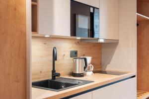 a kitchen with a sink and a coffee maker at Aparthotel Maso Corto in Maso Corto +146 photos