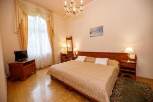 a bedroom with a bed and a television and a chandelier at Bristol Kralovska Vila in Karlovy Vary +53 photos