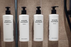 a group of four shampoo bottles on a wall at Aparthotel Maso Corto in Maso Corto
