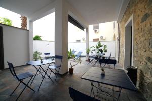 two tables and chairs in a room with windows at SiRiuS rooms & charme in Villasimius