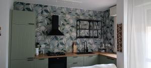 a kitchen with green and white wallpaper and a stove at Casa Soria in Pesaro