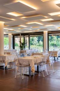 a dining room with tables and chairs and windows at Best Western Plus Carolus Park Hotel in Sutri