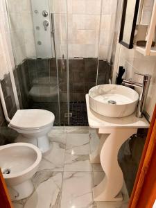 a bathroom with two toilets and a sink and a shower at Noemi Holiday House in Agnone Bagni +33 photos