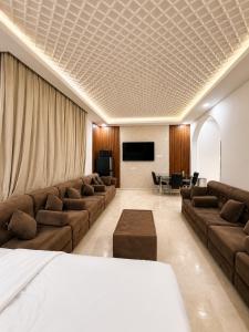 a hotel room with couches and a flat screen tv at Albazar Residence Salalah in Salalah