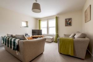 a living room with two couches and a television at The View, 22 School Park in Kingsbarns