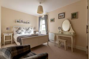 a bedroom with a bed and a mirror and a chair at The View, 22 School Park in Kingsbarns