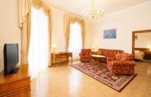 a living room with a couch and a tv at Bristol Kralovska Vila in Karlovy Vary
