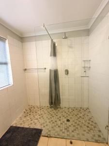 a shower with a glass door in a bathroom at LTB-Waterkant Cottage in Malgas