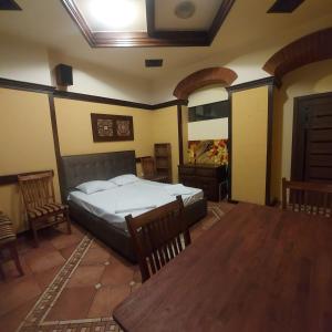 a bedroom with a bed and a table and chairs at Hotel Jan & in the very center in Yerevan
