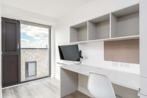 a white office with a white desk and a window at Modern Studios in Central Coventry in Coventry