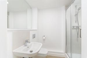 a white bathroom with a sink and a toilet at Modern Studios in Central Coventry in Coventry +16 photos