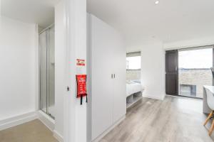 a room with white walls and a bedroom with a bed at Modern Studios in Central Coventry in Coventry