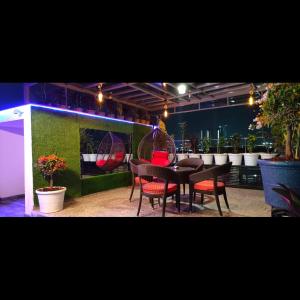 a dining room with a table and red chairs at KPHB Wooden Cottages in Hyderabad