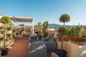 a patio with couches and trees on a roof at Hotel Annabella Roof Terrace in Florence