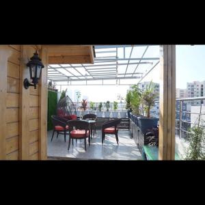 a patio with a table and chairs on a balcony at KPHB Wooden Cottages in Hyderabad