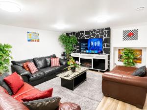 a living room with black leather furniture and a flat screen tv at Cozy 2-Bedroom Suite Near Moncton Hospital & NBCC in Moncton