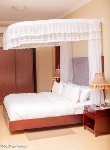 a bedroom with a white bed with a canopy at Kris Star Lodge in Blantyre +18 photos