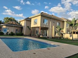 a house with a swimming pool in front of it at Kris Star Lodge in Blantyre