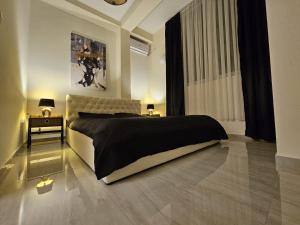 a bedroom with a large bed and a table with lamps at Merter Apartments in Kavadarci