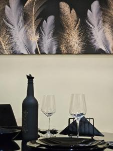 a table with two wine glasses and a bottle at Merter Apartments in Kavadarci +7 photos